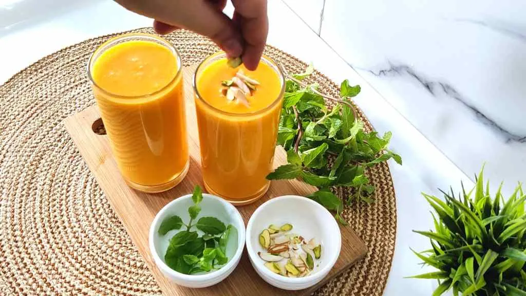 Garnish mango lassi with mint and dry fruits